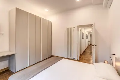 a white bedroom with a large bed and a hallway at Frattina Grand Suite - Vacanze Romane Apartments in Rome