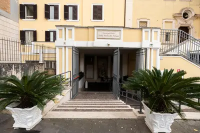 a building with two palm trees in front of it at Casa per Ferie Santa Maria alle Fornaci in Rome