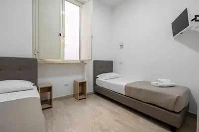 a small bedroom with two beds and a window at Casa per Ferie Santa Maria alle Fornaci in Rome