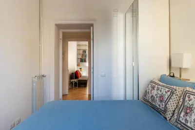 a bedroom with a blue bed and a hallway at Valenziani Escape - Pretty Homes in Rome