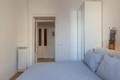 a white bedroom with a bed and a hallway at Valenziani Escape - Pretty Homes in Rome