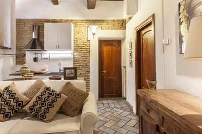 a living room with a couch and a kitchen at Campo dei Fiori Nest Apartment in Rome