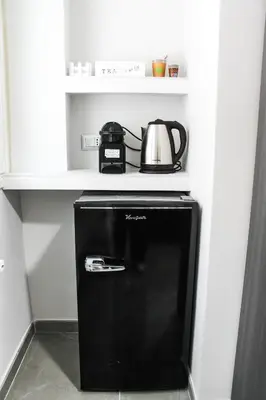 a black refrigerator with a tea kettle on a shelf at Silver Rose Guest House in Rome