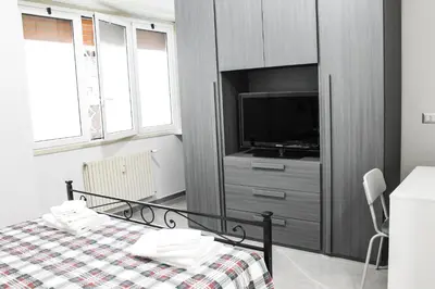 a bedroom with a bed with a tv and a dresser at Silver Rose Guest House in Rome