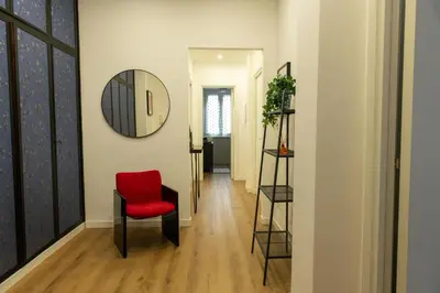 a hallway with a red chair and a mirror at Casa Caterina Holiday House - Bright Modern Apartment Near Trastevere in Rome