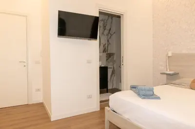 a bedroom with a bed and a television on a wall at Casa Caterina Holiday House - Bright Modern Apartment Near Trastevere in Rome