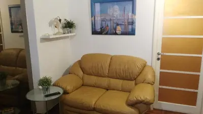 a brown leather couch in a living room with a table at Piccolo Nido in Rome