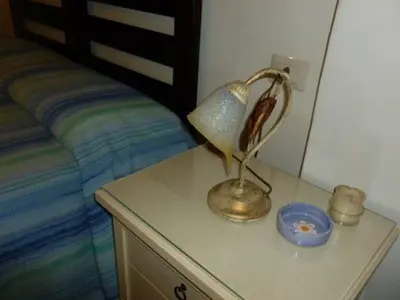 a lamp on a dresser next to a bed at Piccolo Nido in Rome