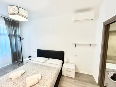 a white room with a bed and a washing machine at Un Letto Ideale EUR - UN LETTO IDEALE in Rome