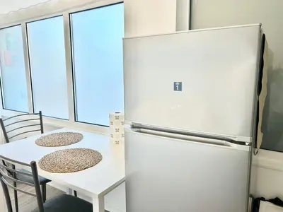 a kitchen with a refrigerator and a table at Un Letto Ideale EUR - UN LETTO IDEALE in Rome