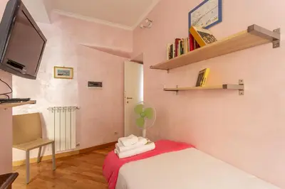 a room with a bed and a tv and a chair at iFlat Bright & Comfortable Navona apartment in Rome