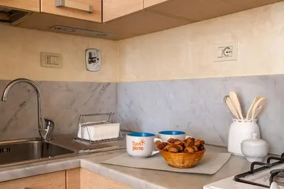 a kitchen counter with two cups and a basket of mushrooms at iFlat Bright & Comfortable Navona apartment in Rome
