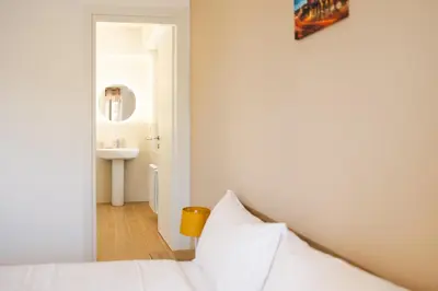 a bedroom with a white bed and a sink at Domus Angelina in Rome