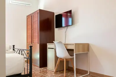a bedroom with a desk and a chair next to a bed at Domus Angelina in Rome