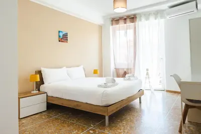 a bedroom with a large white bed and a window at Domus Angelina in Rome