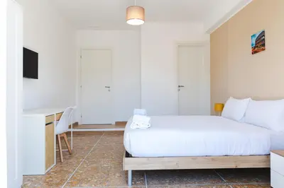a bedroom with a white bed and a desk at Domus Angelina in Rome