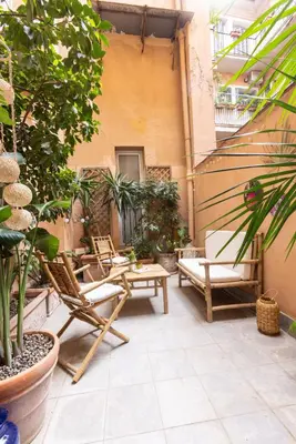 a patio with chairs and tables and potted plants at Dolce Far Niente in Rome