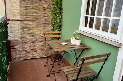 a table and chairs on a patio with a window at Roux apartment in Rome