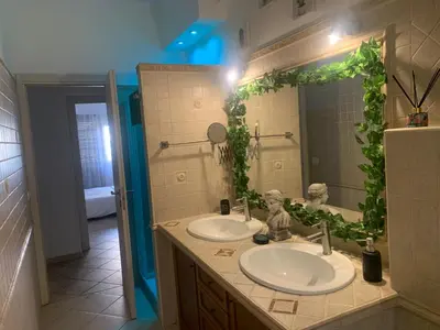 a bathroom with two sinks and a large mirror at Roux apartment in Rome