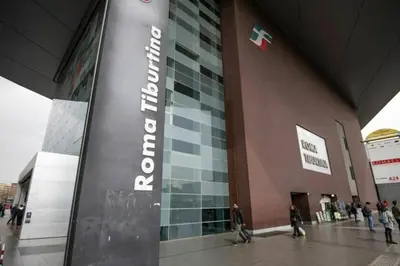 a sign in front of a building with people walking at Roux apartment in Rome