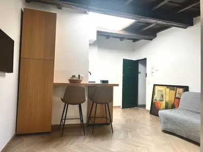 a kitchen with two stools and a counter in a room at Trastevere Grand Suites in Rome