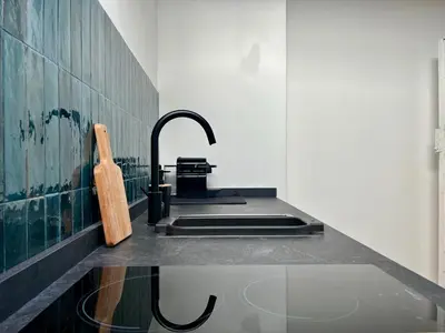 a kitchen with a sink with a wooden cutting board at Trastevere Grand Suites in Rome