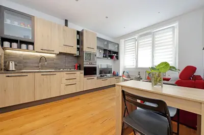 a kitchen with wooden cabinets and a wooden table at Vestali House in Rome