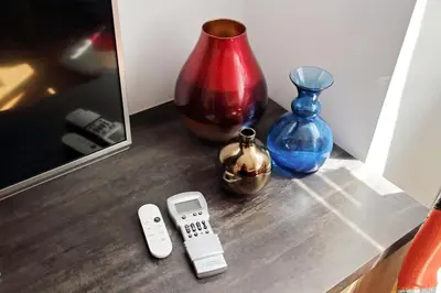 a table with a remote control and some vases at Vestali House in Rome