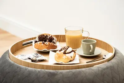 a table with a tray of donuts and a glass of orange juice at Domina Apartments Roma - San Pietro 2 in Rome