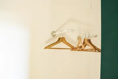 a wooden rack with hangers on a wall at Domina Apartments Roma - San Pietro 2 in Rome