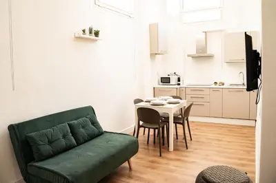 a living room with a green couch and a table at Domina Apartments Roma - San Pietro 2 in Rome