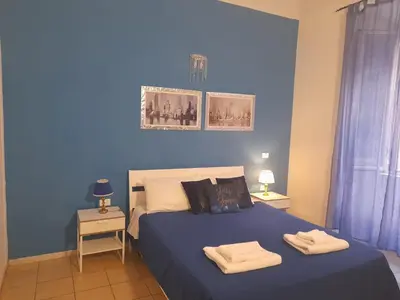 a blue bedroom with a bed with two towels on it at Casa Roma Affittacamere in Rome