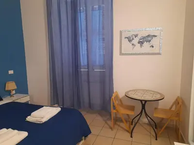 a room with a bed and a table and a window at Casa Roma Affittacamere in Rome