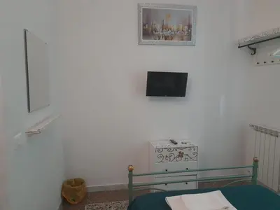 a bedroom with a bed and a tv on a wall at Casa Roma Affittacamere in Rome
