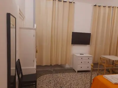 a room with a television and a dresser with a table at Casa Roma Affittacamere in Rome