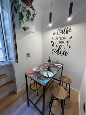 a table in a room with two chairs and a sign on the wall at Basilica San Giovanni Appia Antica A casa di Amici in Rome