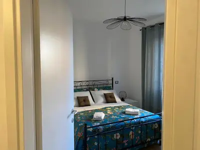 a bedroom with a bed with a blue comforter at Vatican flat family suite in Rome