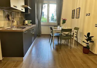 a dining room table with a vase of flowers on it at Vatican flat family suite in Rome