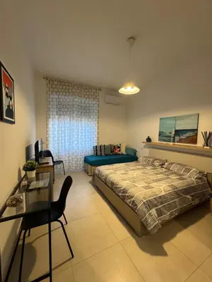 a bedroom with a bed and a table and a chair at Alba Nuova Suite in Rome