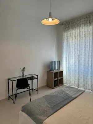 a bedroom with a bed and a table and a desk at Alba Nuova Suite in Rome