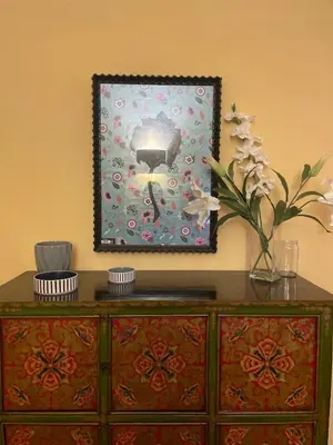 a dresser with a mirror and a vase with flowers on it at Giglio apartment Navona in Rome