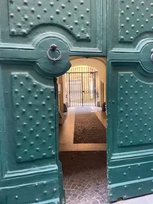 a green door with a handle in a hallway at Giglio apartment Navona in Rome