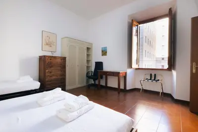 a bedroom with two beds and a desk and a window at A casa da Giordi in Rome
