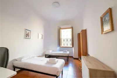 a small room with two beds and a window at A casa da Giordi in Rome