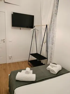a bedroom with a bed with two towels and a flat screen tv at Harmony in Rome ll in Rome
