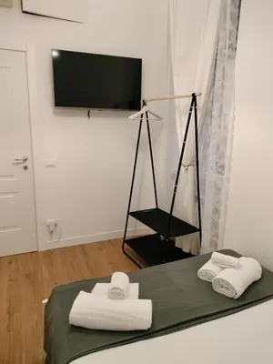 a room with a bed with towels and a flat screen tv at Harmony in Rome ll in Rome
