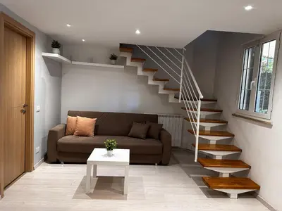 a living room with a couch and a staircase at Casa di Nia Pietralata in Rome