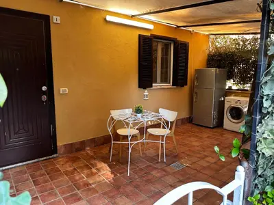 a patio with a table and chairs and a refrigerator at Casa di Nia Pietralata in Rome