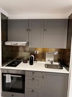 a kitchen with white cabinets and a sink at Casa di Nia Pietralata in Rome