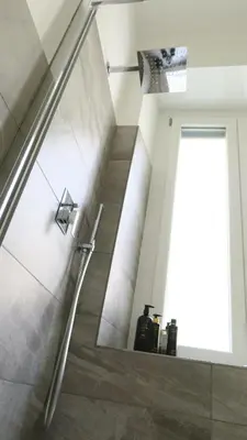 a bathroom with a walk in shower next to a staircase at Scipioni245 Charme Apartment in Rome